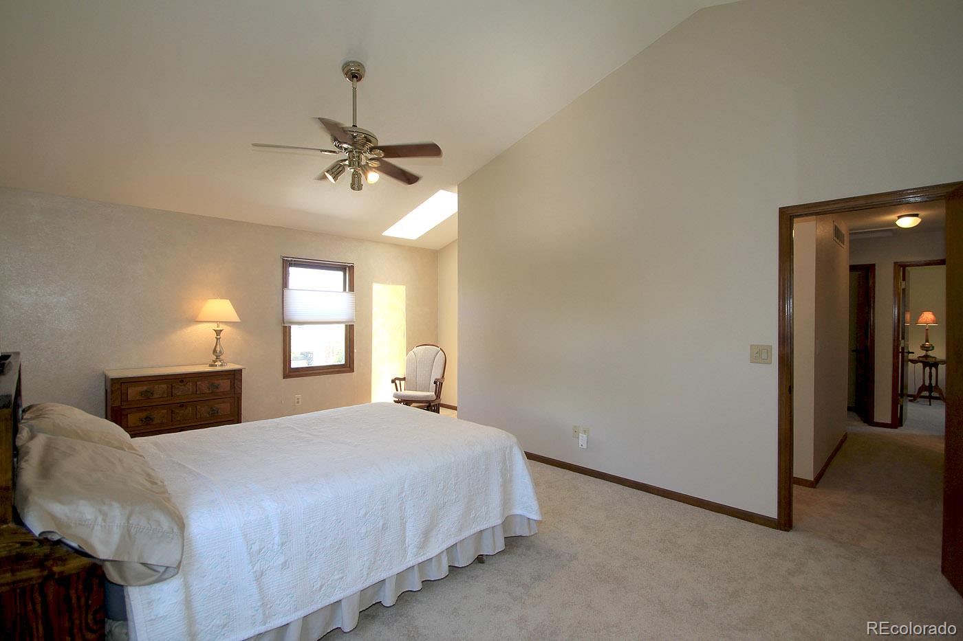 8198 Sweet Water Road Lone Tree, CO 80124 - Photo 13 of 23 a bedroom with a bed ceiling fan and window