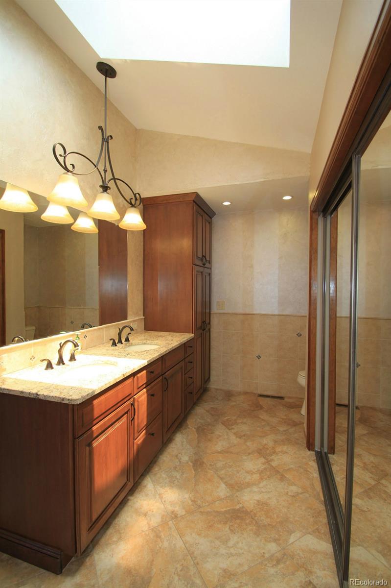 8198 Sweet Water Road Lone Tree, CO 80124 - Photo 15 of 23 a bathroom with a sink mirror and shower