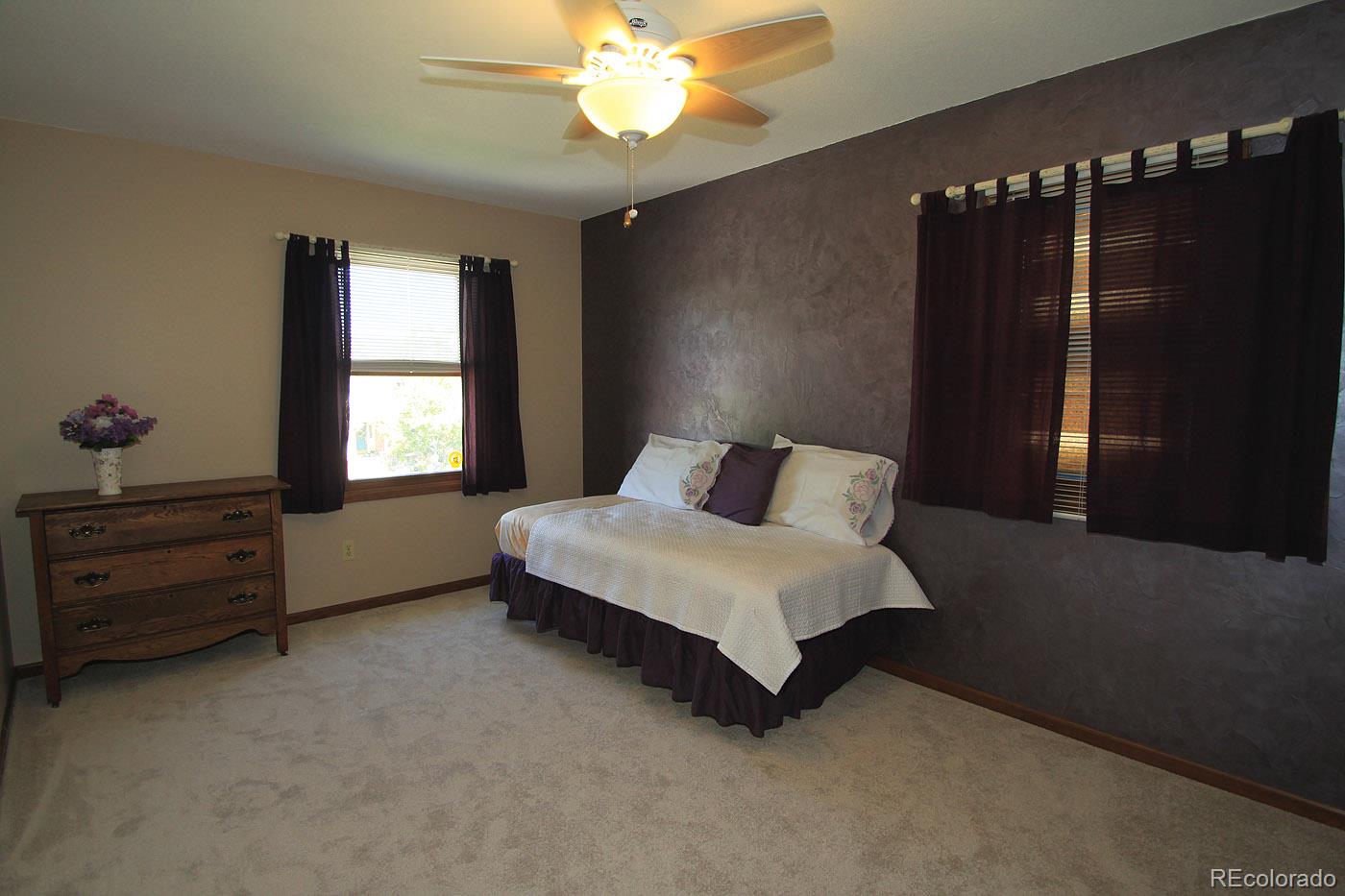8198 Sweet Water Road Lone Tree, CO 80124 - Photo 18 of 23 a spacious bedroom with a bed and a window