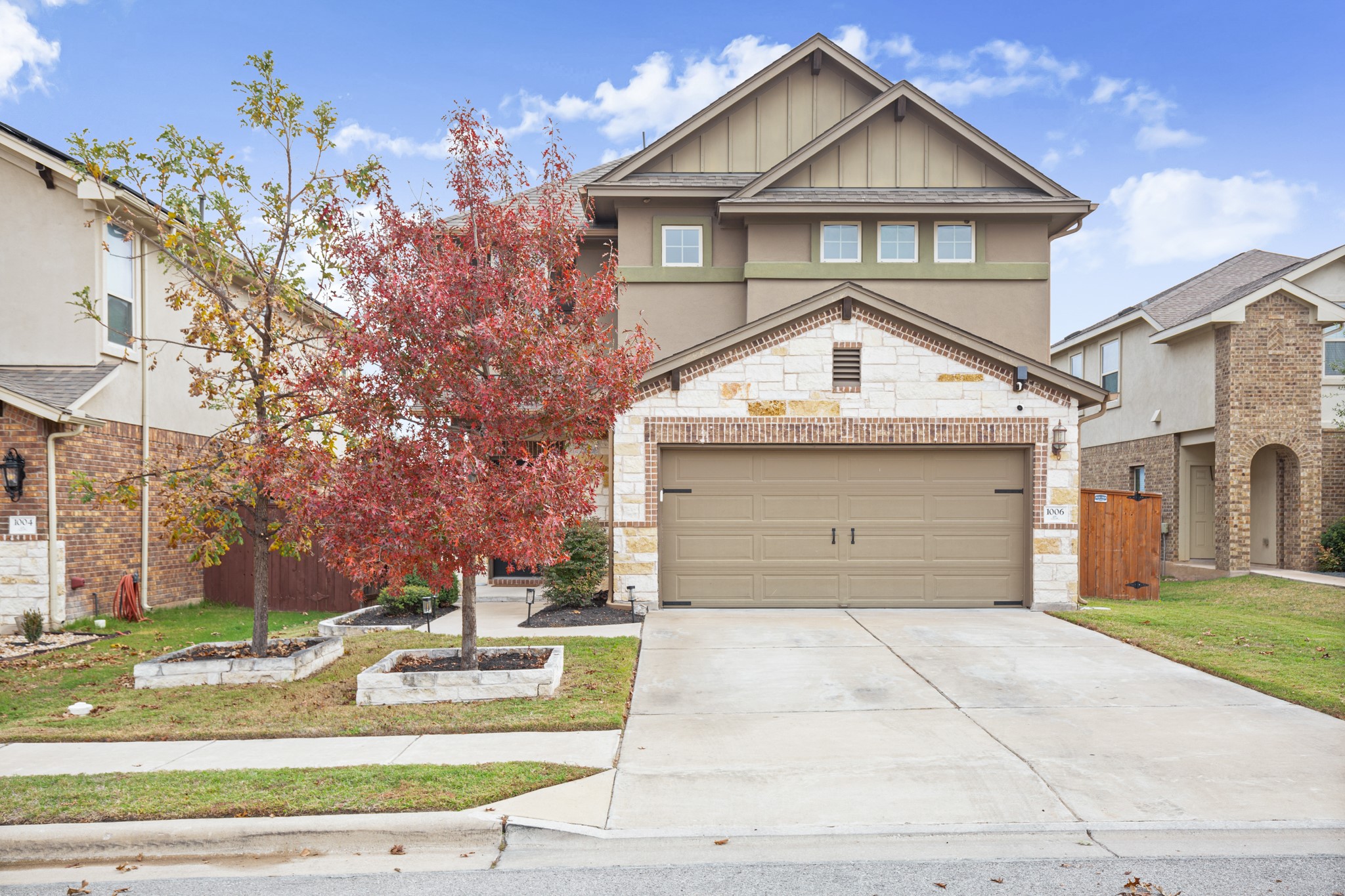 Craftsman-style home with driveway, board and batten siding, a garage, and stone siding