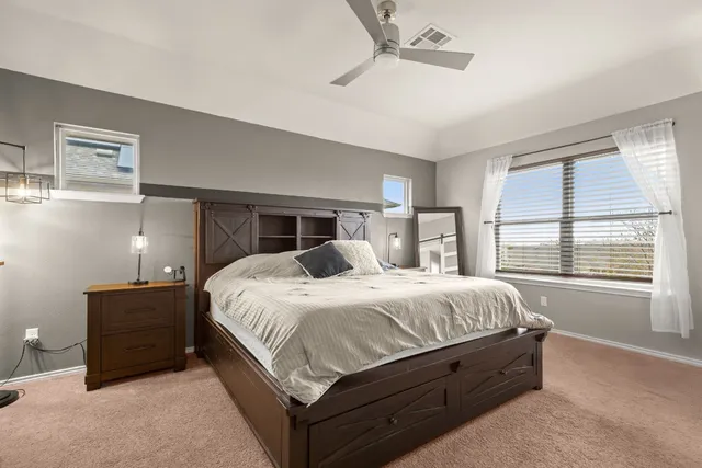 a large bed sitting in a bedroom next to a window