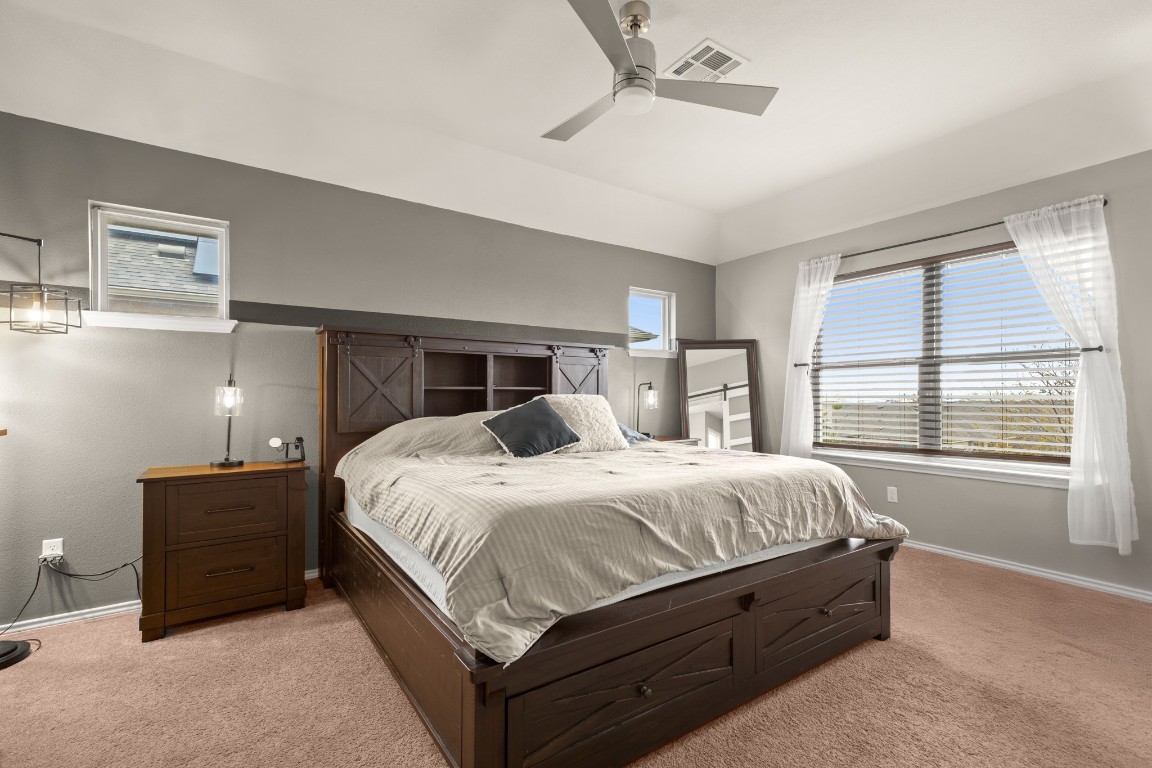 1006 Chad Loop Round Rock, TX 78665 - Photo 13 of 26 a large bed sitting in a bedroom next to a window