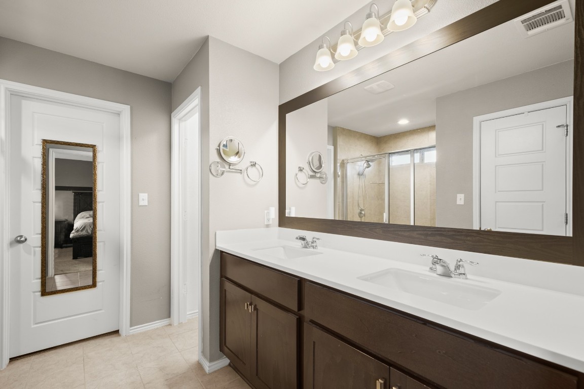 1006 Chad Loop Round Rock, TX 78665 - Photo 15 of 26 a bathroom with a double vanity sink and a mirror