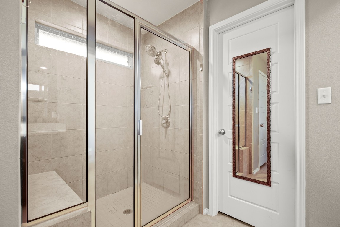 1006 Chad Loop Round Rock, TX 78665 - Photo 16 of 26 a bathroom with a glass shower door