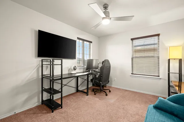 a view of a livingroom with workspace and a window