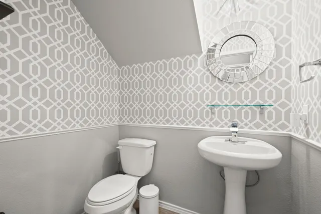 a bathroom with a toilet sink and mirror