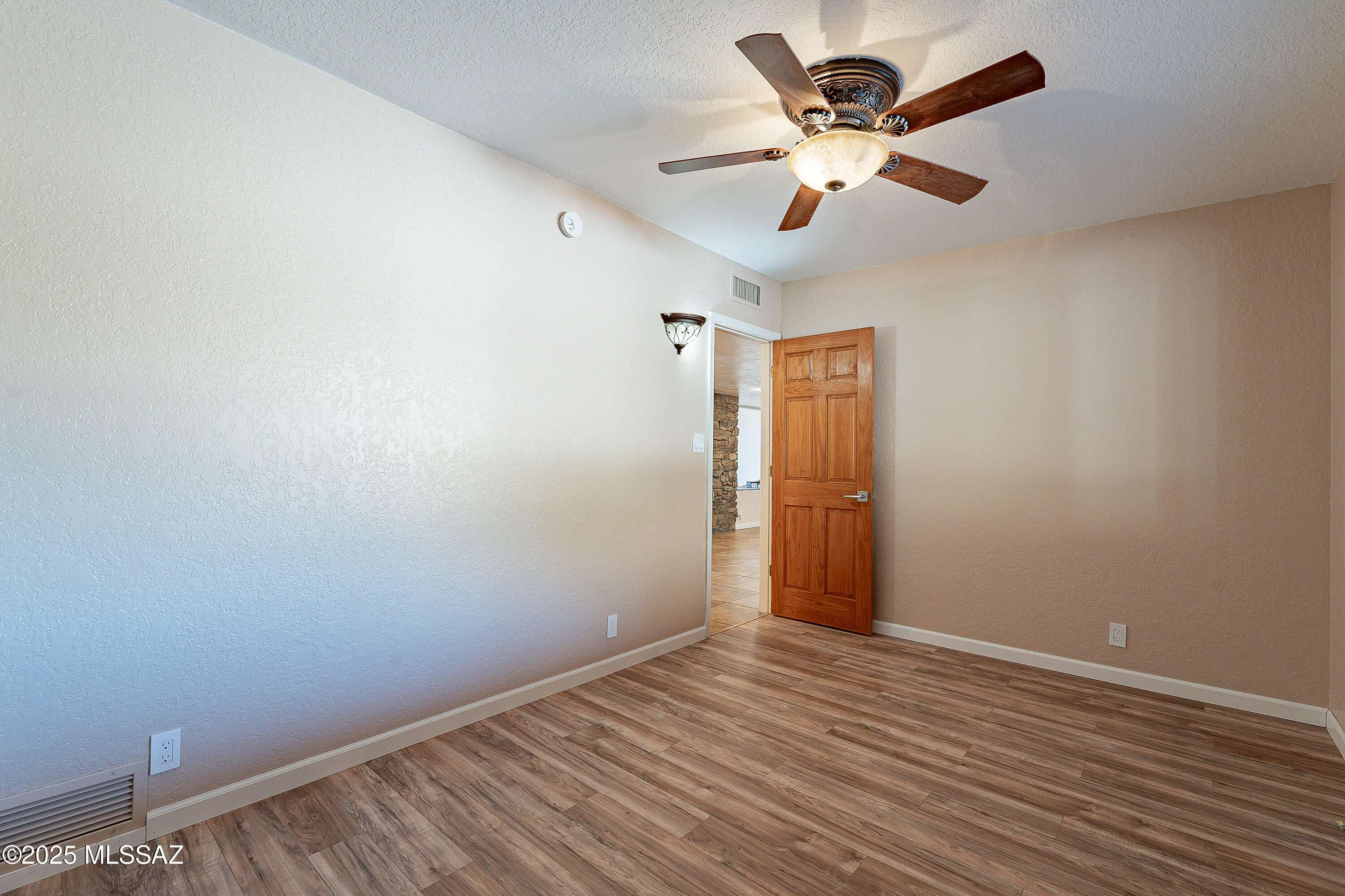 467 Camino Osito Rio Rico, AZ 85648 - Photo 30 of 50 an empty room with wooden floor and ceiling fan