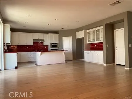 a view of a kitchen with furniture and wooden floor