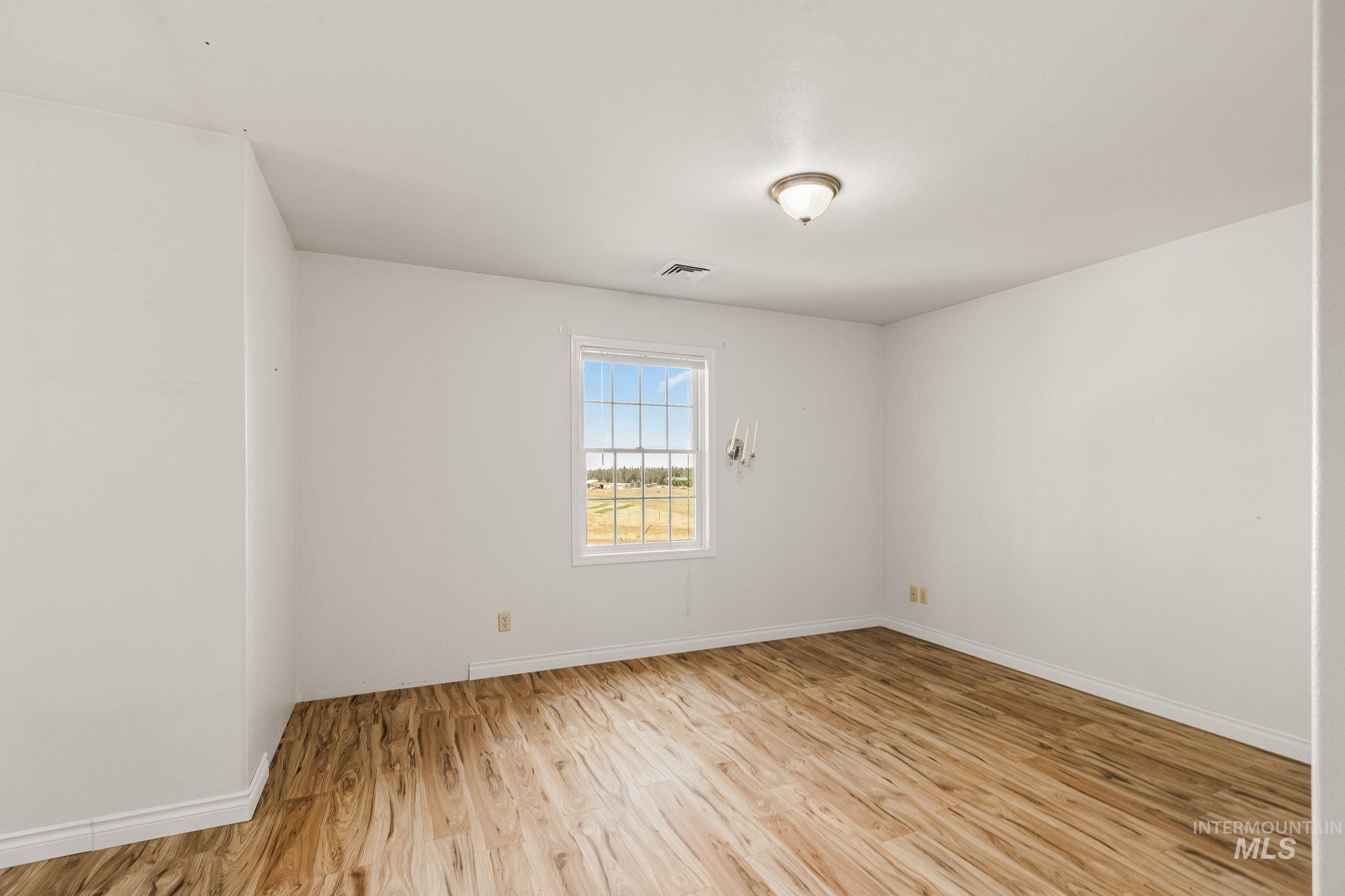 1820 Winchester Road Winchester, ID 83555 - Photo 24 of 50 Wood-finish flooring, white walls, and a window with grid patterns