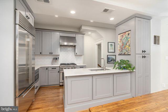 a kitchen with stainless steel appliances granite countertop a stove a sink and a refrigerator