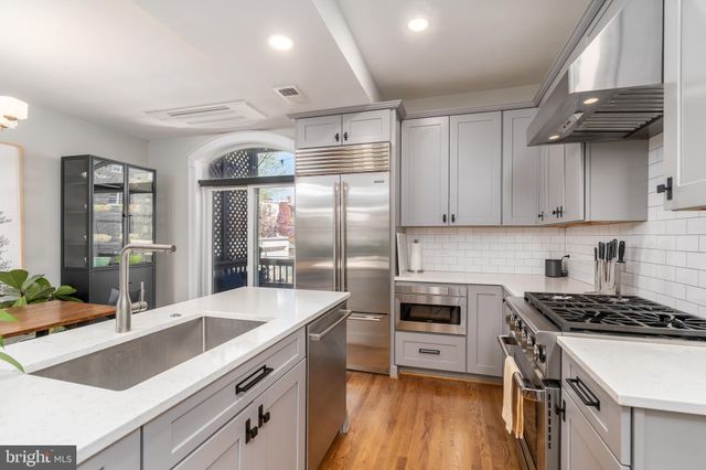 a kitchen with granite countertop a sink stainless steel appliances and cabinets