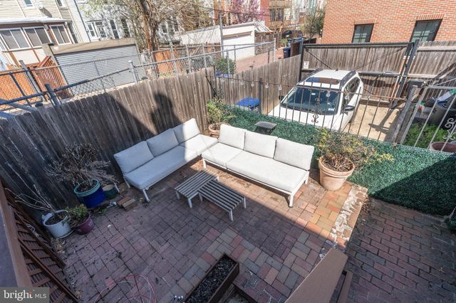 a view of a patio with couches table and chairs and potted plants