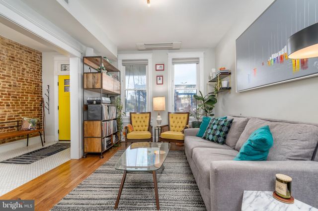 a living room with furniture wooden floor and a rug