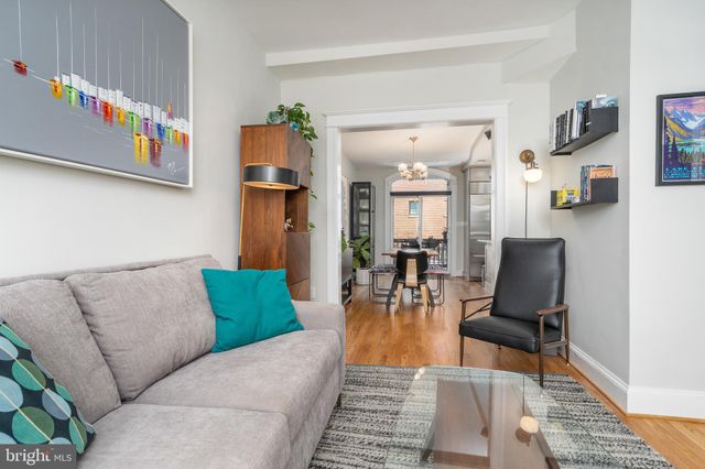 a living room with furniture and painting on the wall