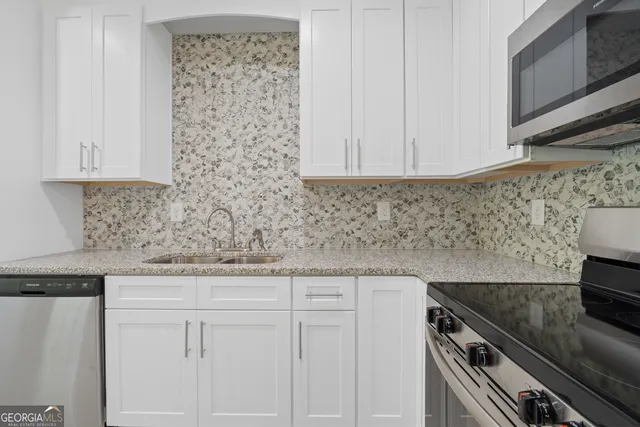 a view of kitchen with granite countertop cabinets and refrigerator