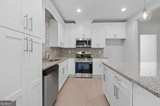 an empty room with a windows and chandelier