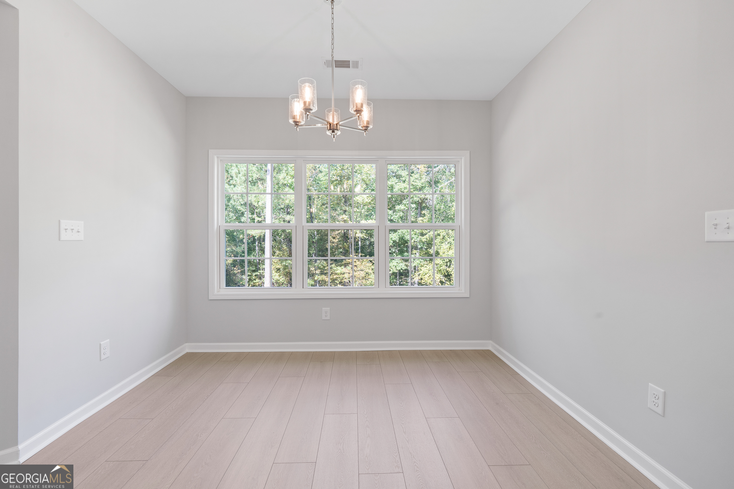 4477 Rivercliff Way Gray, GA 31032 - Photo 30 of 62 an empty room with a windows and chandelier