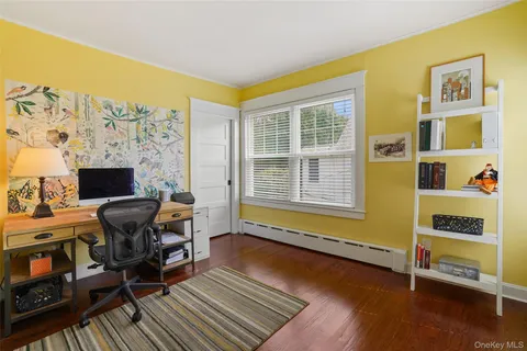 a view of a workspace with furniture and a window