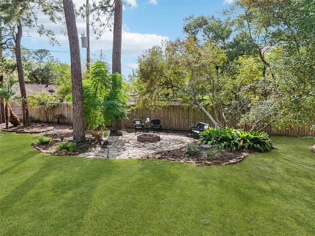 a view of a backyard with plants and a fountain
