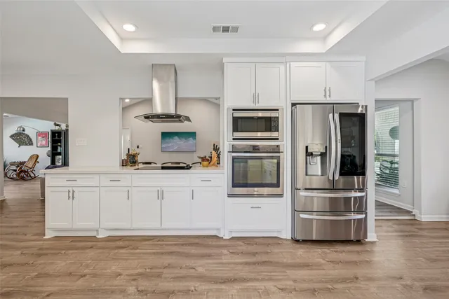 a kitchen with stainless steel appliances kitchen island granite countertop a refrigerator and a stove top oven