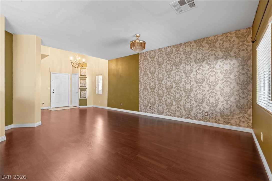 8934 Deep Ridge Court Las Vegas, NV 89178 - Photo 7 of 47 Lustrous wood flooring stretches through this open-concept living space, illuminated by elegant chandeliers.