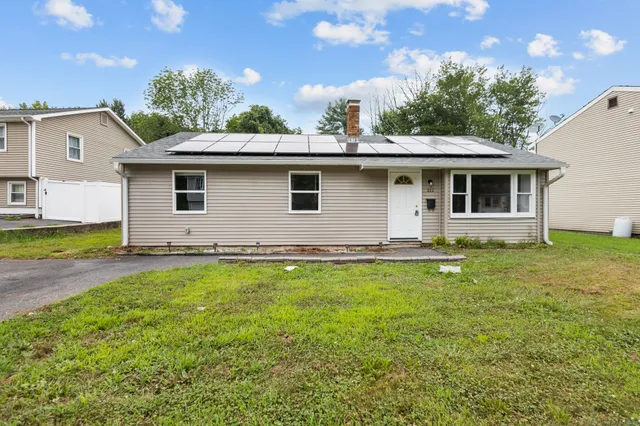 a view of a house with backyard and sitting area