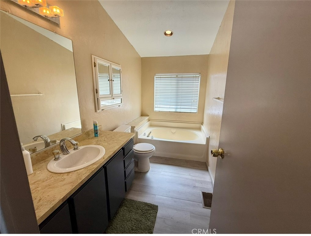 4080 Pedley Road, Unit 189 Jurupa Valley, CA 92509 - Photo 11 of 16 a bathroom with a granite countertop sink a toilet a mirror and bathtub