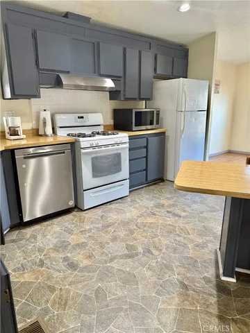a kitchen with a stove top oven cabinets and refrigerator