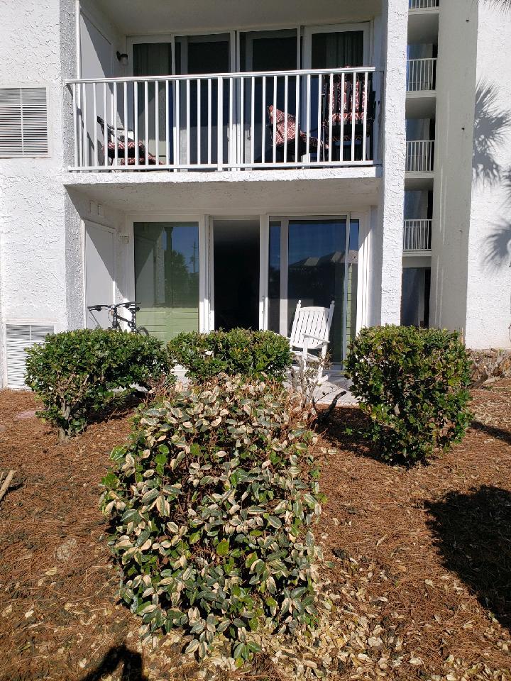 30 Moreno Point Road, Unit 102A Destin, FL 32541 - Photo 21 of 52 a front view of a house with a garden