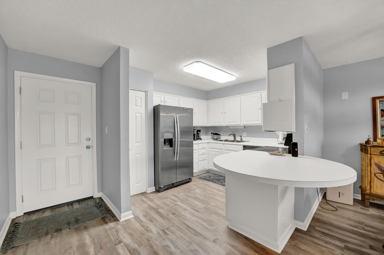 30 Moreno Point Road, Unit 102A Destin, FL 32541 - Photo 22 of 52 a large white kitchen with a sink a refrigerator and white cabinets