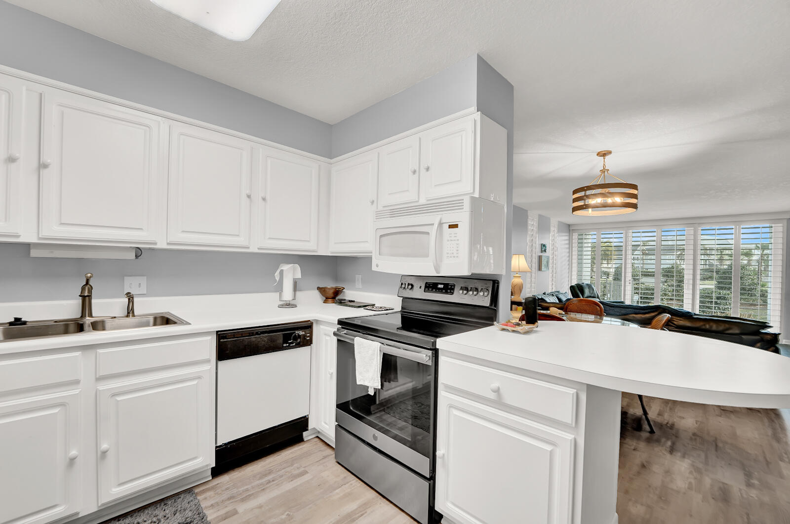 30 Moreno Point Road, Unit 102A Destin, FL 32541 - Photo 25 of 52 a kitchen with stainless steel appliances a stove a sink and white cabinets