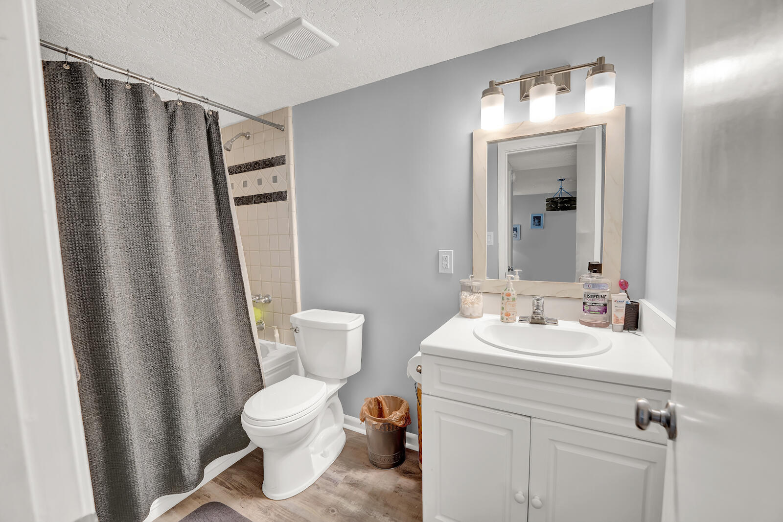 30 Moreno Point Road, Unit 102A Destin, FL 32541 - Photo 5 of 52 a bathroom with a sink a toilet a mirror and shower curtain