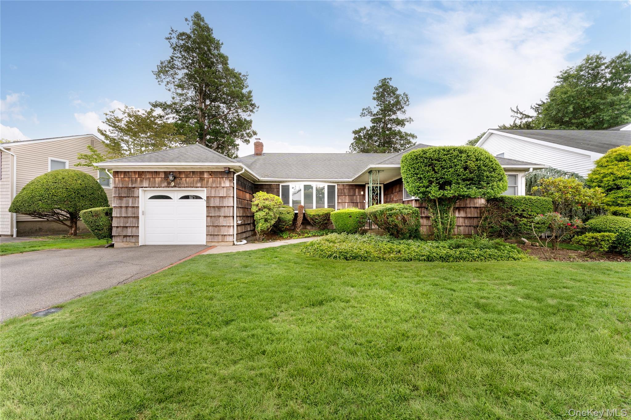 9 Eaton Road Syosset, NY 11791 - Photo 1 of 1 a front view of a house with a yard and garage