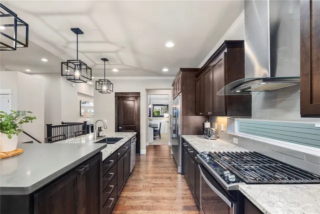 a kitchen with stainless steel appliances a sink stove and cabinets
