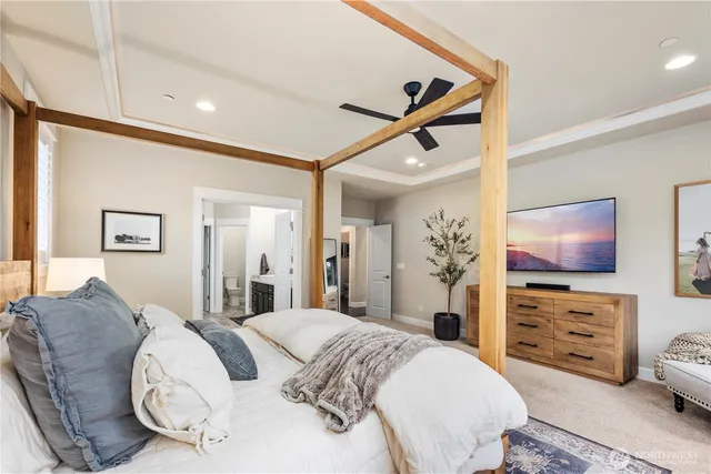 a spacious bedroom with a bed and a flat screen tv