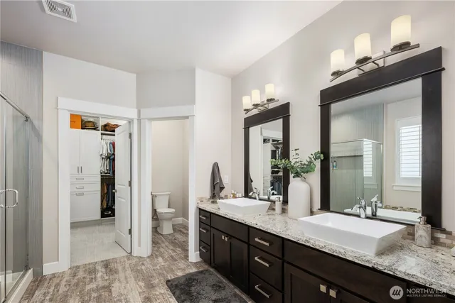 a bathroom with a granite countertop sink a mirror and a shower