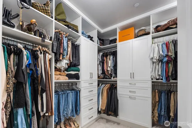 a view of walk in closet with clothes and shoes
