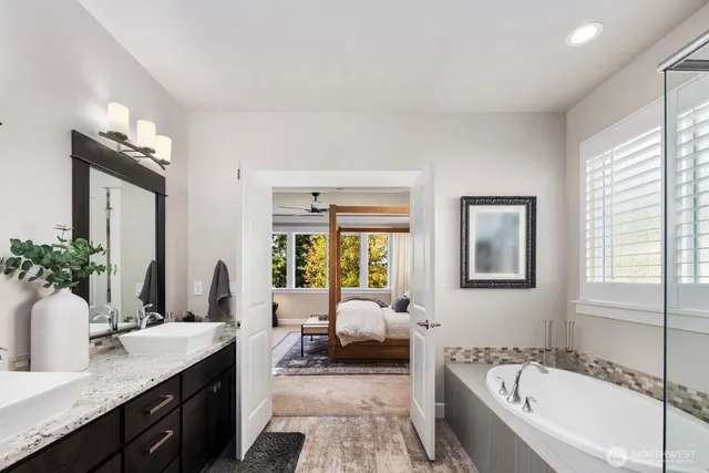 a spacious bathroom with a granite countertop tub sink and mirror