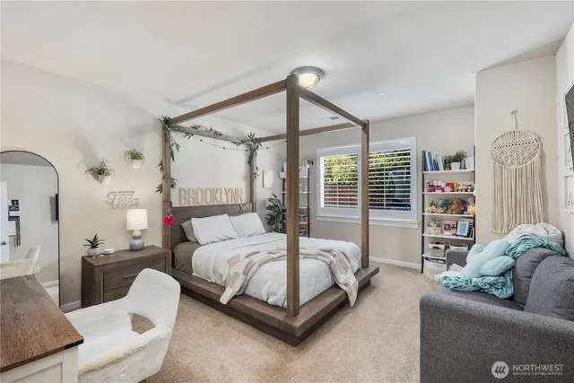 a bedroom with a bed a couch and a large window