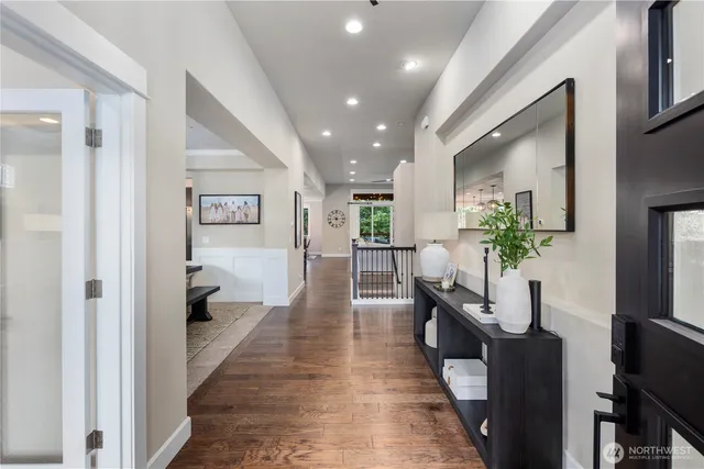 a hallway with wooden floor and a potted plant
