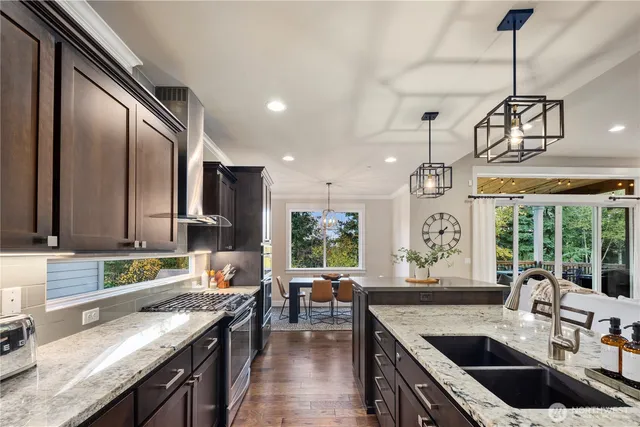 a kitchen with stainless steel appliances granite countertop a sink stove and refrigerator