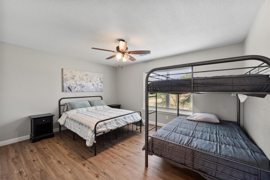 113 Cinch Buckle Ranch Road Trinidad, TX 75163 - Photo 27 of 36 a bedroom with a large bed and a chandelier