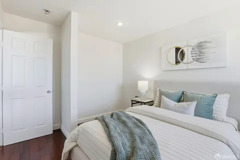 a bedroom with a large bed and a chandelier