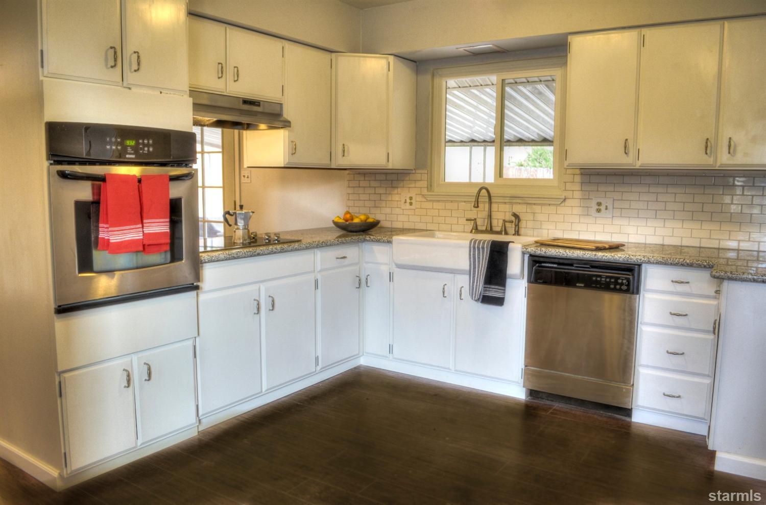 1095 Kings Row Reno, NV 89503 - Photo 16 of 23 a kitchen with granite countertop white cabinets and white appliances