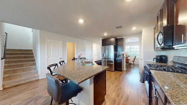 a kitchen with sink refrigerator dining table and chairs