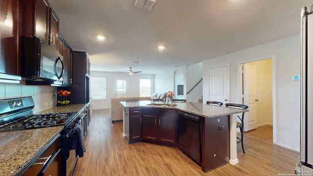 a kitchen with granite countertop a sink stove and cabinets