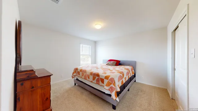 a bedroom with a bed and a potted plant