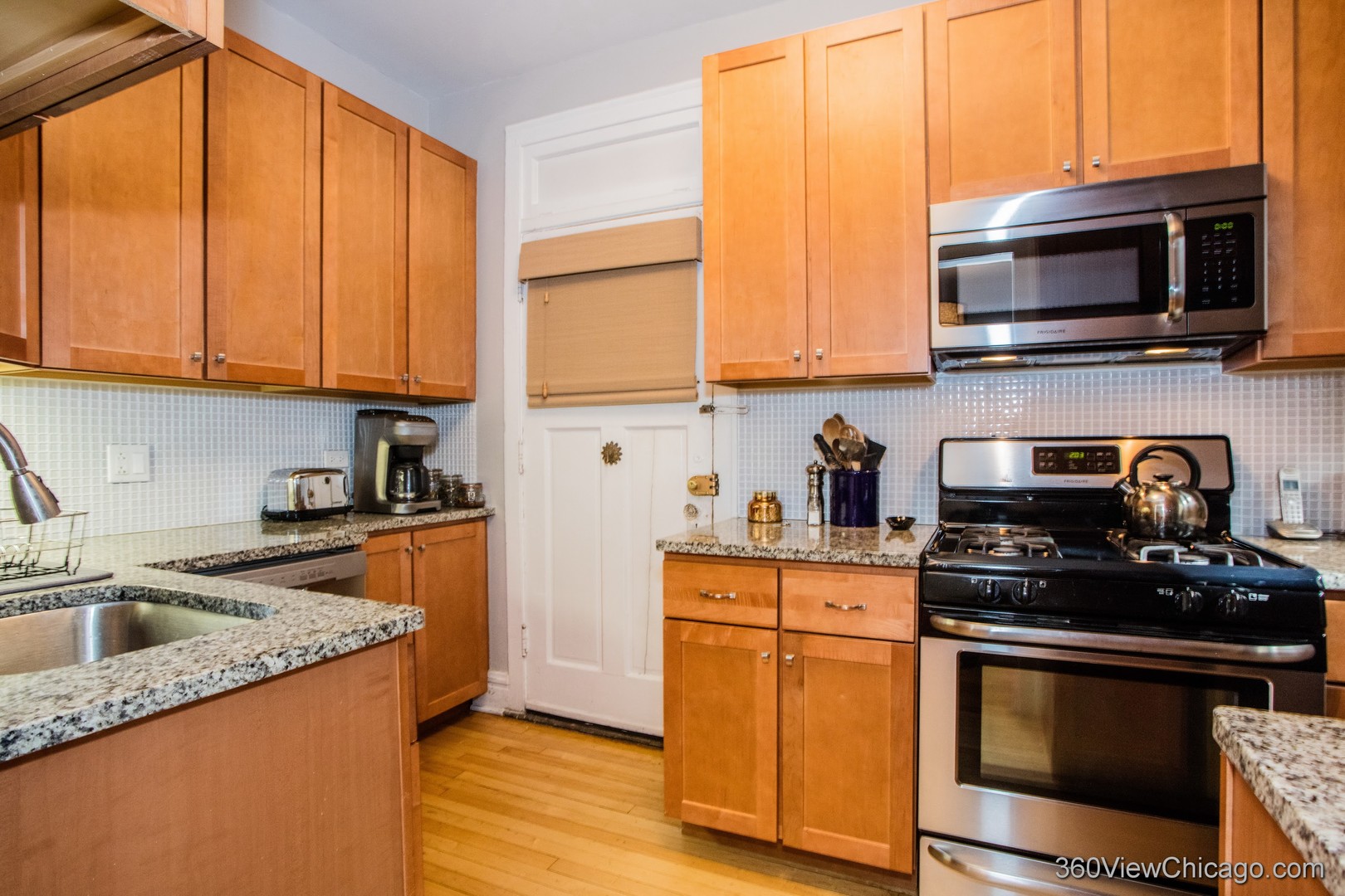 546 West Brompton Avenue, Unit 2S Chicago, IL 60657 - Photo 11 of 17 a kitchen with stainless steel appliances granite countertop a sink a stove and a microwave