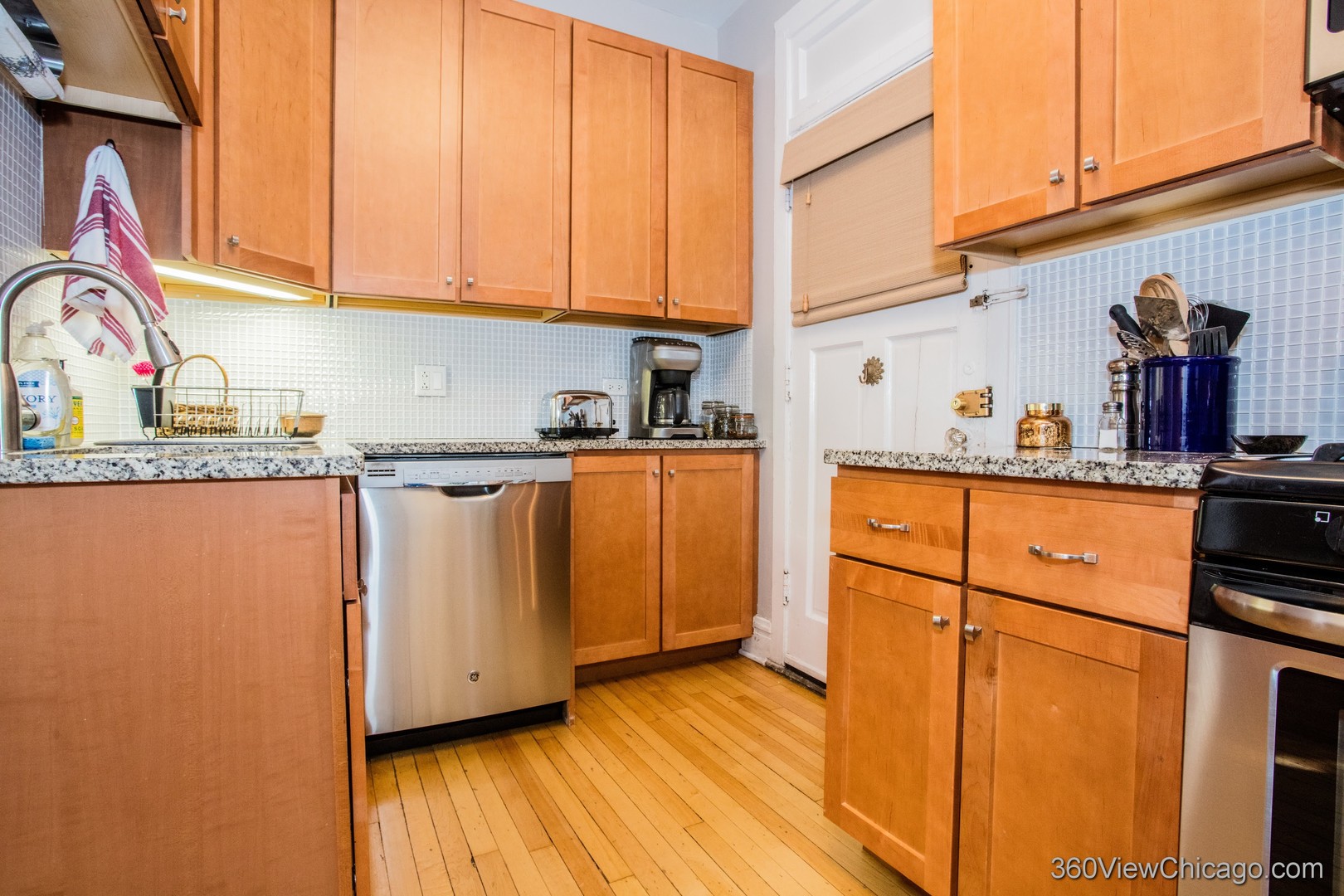 546 West Brompton Avenue, Unit 2S Chicago, IL 60657 - Photo 10 of 17 a kitchen with granite countertop wooden cabinets and white appliances