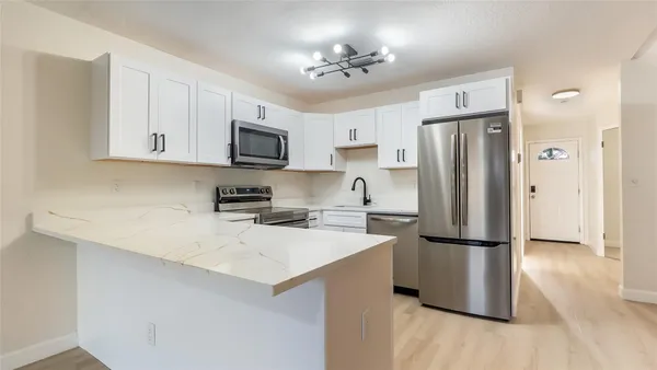 a kitchen with a refrigerator a stove top oven a sink and cabinets